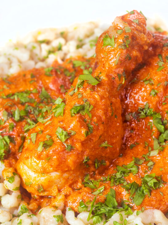 Close-up Hungarian chicken paprikash or csirkepaprikás in a paprika sauce with nokedli.