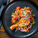 Overhead Indian influenced one pot baked chicken legs and basmati rice.