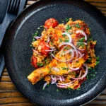 Overhead Indian influenced one pot baked chicken legs and basmati rice.