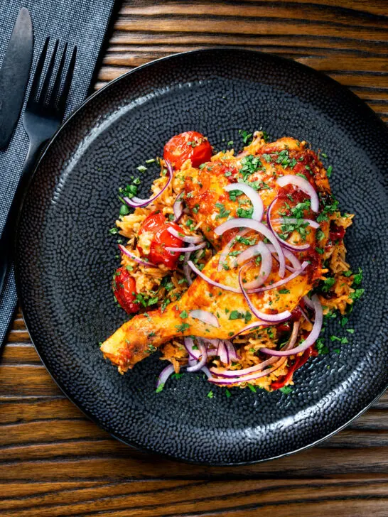 Overhead Indian influenced one pot baked chicken legs and basmati rice.