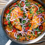 Overhead Indian influenced one pot baked chicken legs and rice in a skillet.