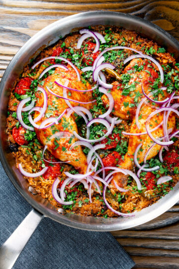 Overhead Indian influenced one pot baked chicken legs and rice in a skillet.