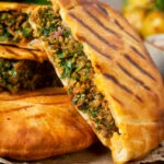 Close-up minced lamb meat arayes or stuffed pita breads.