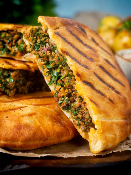 Close-up minced lamb meat arayes or stuffed pita breads.