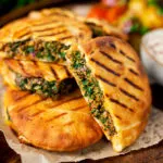Minced lamb arayes stuffed pita breads served with batata harra.