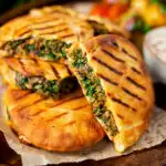 Minced lamb arayes stuffed pita breads served with batata harra featuring a title overlay.