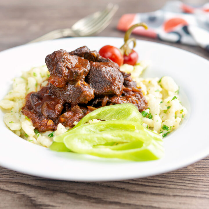 Marha porkolt or pörkölt beef stew swerved with nokedli and pickled peppers.