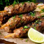 Minced lamb kofta kebab skewers with a lime wedge featuring a title overlay.