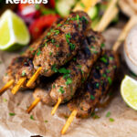 Minced lamb kofta kebab skewers with lime wedges and salad featuring a title overlay.