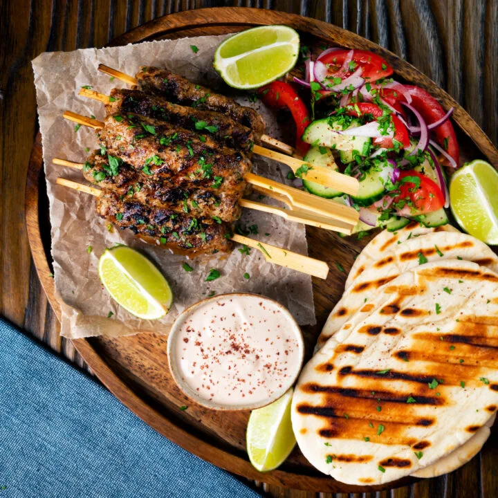 Minced lamb kofta kebab skewers served with pitas, yoghurt dip and salad.