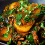 Close-up Indian spinach and potato curry or saag aloo served with homemade chapatis.
