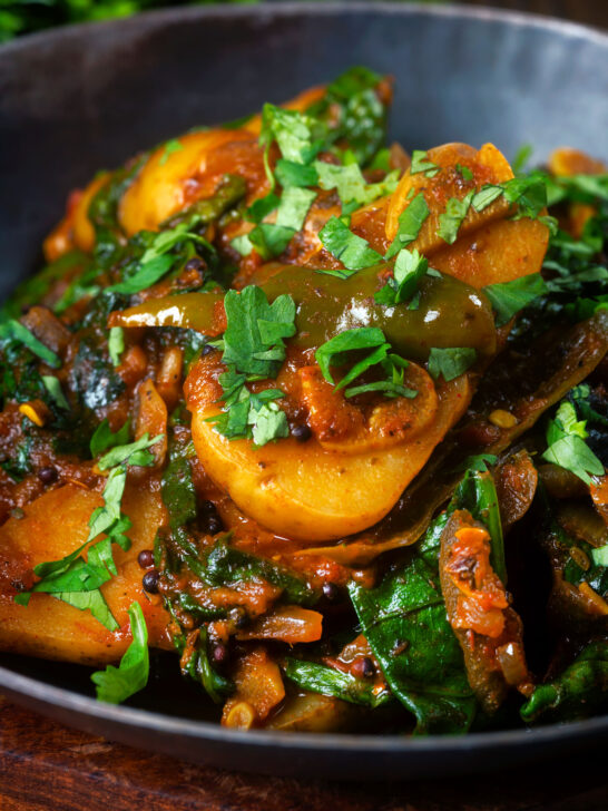 Close-up Indian spinach and potato curry or saag aloo served with homemade chapatis.