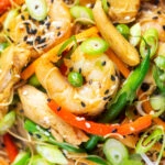 Overhead close-up curried Singapore chow mein noodles with chicken and prawns.