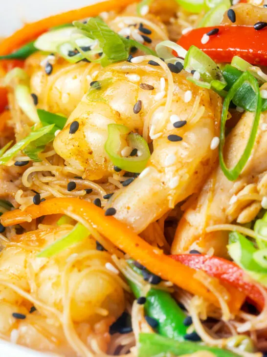 Close-up curried Singapore chow mein noodles with chicken and prawns.