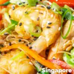 Close-up curried Singapore chow mein noodles with chicken and prawns featuring a title overlay.