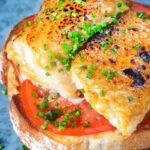 Smoked haddock Welsh rarebit on toast with beef tomatoes and chives.