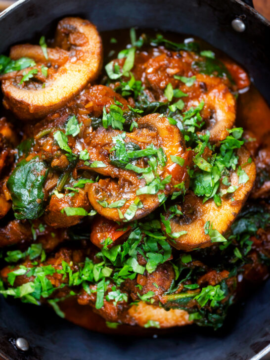 Overhead close-up vegan spinach and mushroom Indian inspired curry.