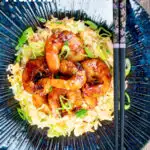 Overhead quick spicy teriyaki prawns or shrimp stir fry served with egg fried rice featuring a title overlay.