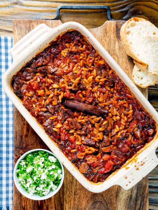 Overhead Greek baked youvetsi or giouvetsi with lamb and orzo in a baking dish.