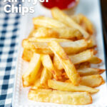 Air fryer golden crispy British chips served with a bowl of ketchup featuring a title overlay.