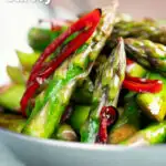 Stir fried asparagus with soy sauce, garlic and chilli featuring a title overlay.