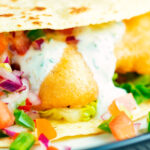 Close-up beer battered crispy cod fish tacos in a corn tortilla.