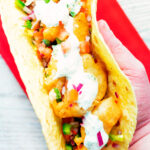 Overhead beer battered crispy cod fish tacos in a corn tortilla.