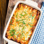 Overhead minced beef stuffed cannelloni pasta topped with bechamel and mozzarella cheese.
