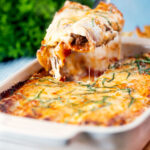 Portion of beef stuffed cannelloni with a bechamel topping removed from a baking dish.