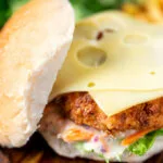 Buttermilk fried chicken burger with a bitter chicory slaw, topped with Swiss cheese.