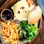 Buttermilk fried chicken burger with Swiss cheese served with French fries.