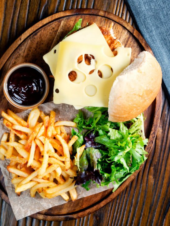 Buttermilk fried chicken burger with Swiss cheese served with French fries.