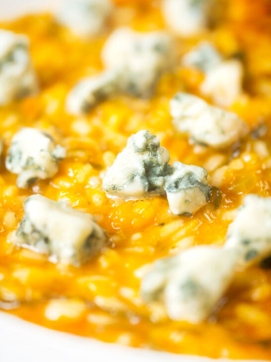 Close-up butternut squash and sage risotto served with Roquefort cheese.