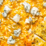Overhead close-up butternut squash and sage risotto served with Roquefort cheese.