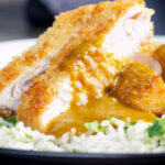 Close-up crispy fried chicken katsu curry with homemade kare sauce served with rice.