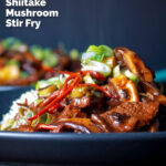 Close up steak and shiitake mushroom stir fry serve with rice featuring a title overlay.