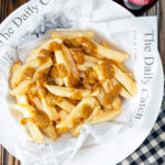 Overhead British chip shop chips served with a homemade chippy curry sauce.