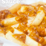 Close-up British chip shop chips served with a homemade chippy curry sauce featuring a title overlay.