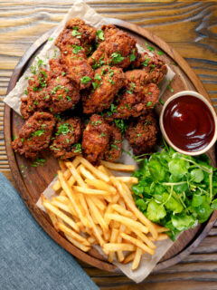 Overhead crispy fried buttermilk chicken wings with fries and sauce.