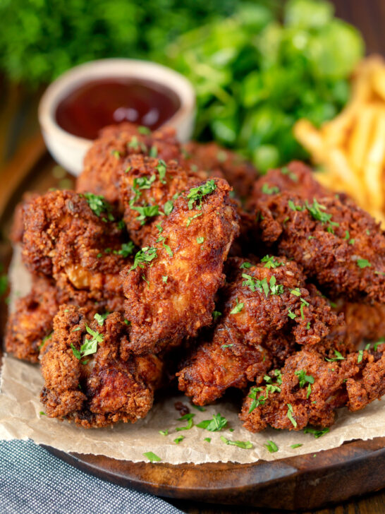 Crispy fried buttermilk chicken wings with fries and sauce.