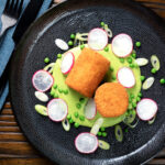Overhead fried crumbed goat cheese with sweet pea puree, radishes and spring onions.