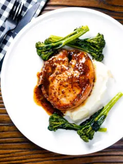 Overhead thick cut honey mustard pork chops with roasted tenderstem broccoli and mashed potato.