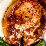Overhead close-up thick cut honey mustard pork chops with roasted tenderstem broccoli and mashed potato.