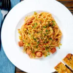 Overhead hot dog pasta topped with crispy onions and mustard breadcrumbs.