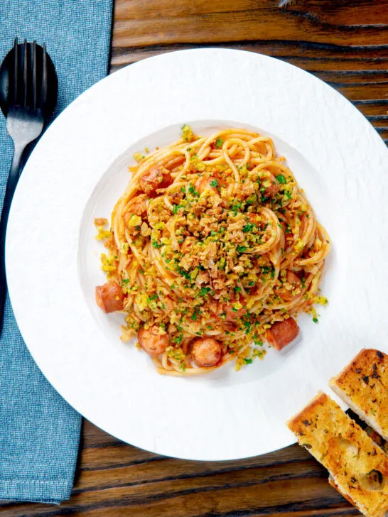 Overhead hot dog pasta topped with crispy onions and mustard breadcrumbs.