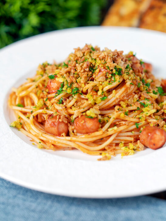 Hot dog spaghetti topped with crispy onions and mustard breadcrumbs.