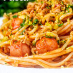 Close-up hot dog spaghetti topped with crispy onions and mustard breadcrumbs Featuring a title overlay.