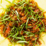Overhead close-up sausage ragu made with Italian sausages and tomatoes served with polenta.