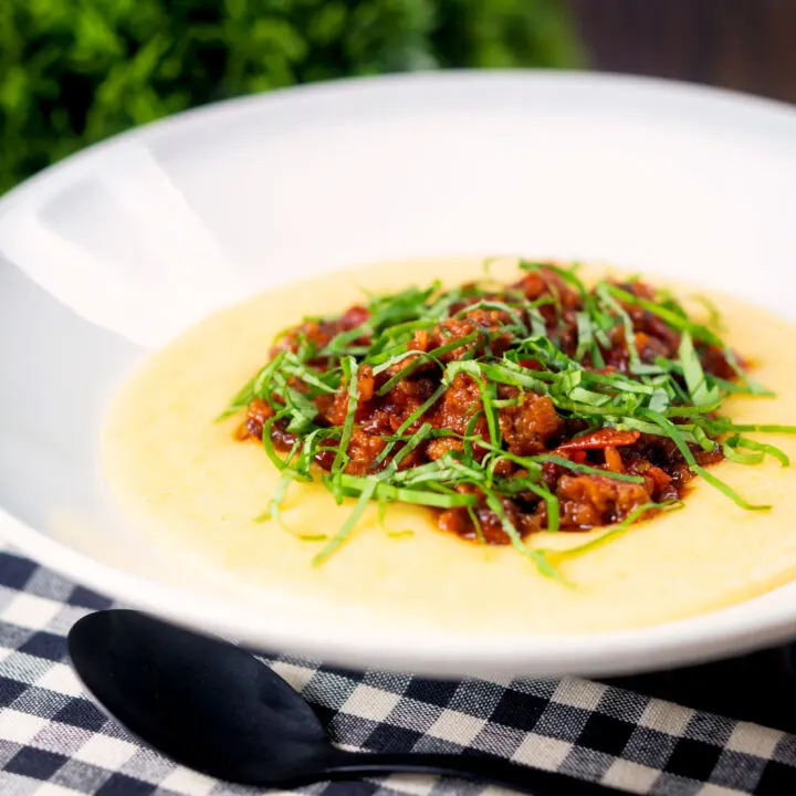 A simple rich Italian sausage ragu served on a bed of cheesy polenta.