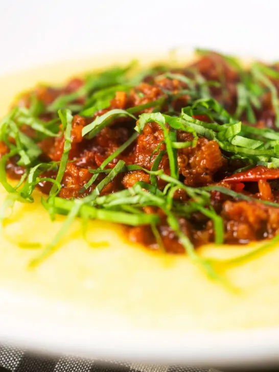 Close-up sausage ragu made with Italian sausages and tomatoes served with polenta.